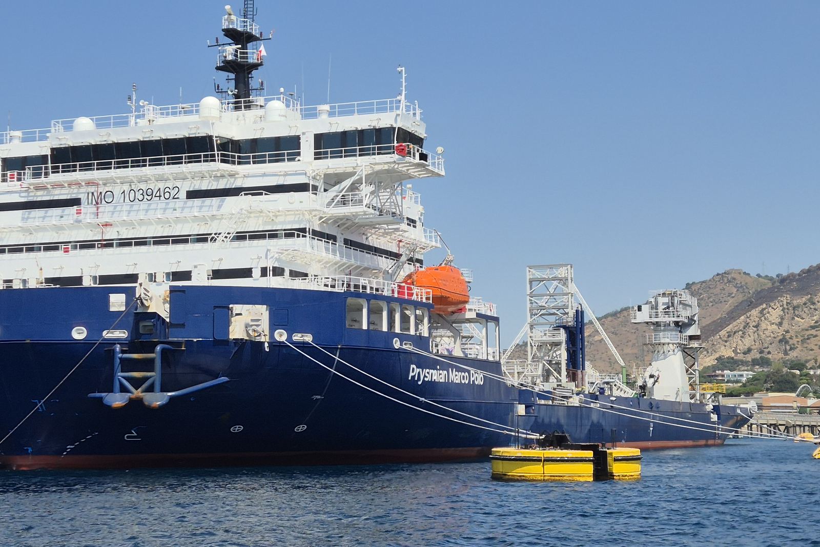 Ice-class vessel alongside a quay under a clear sky