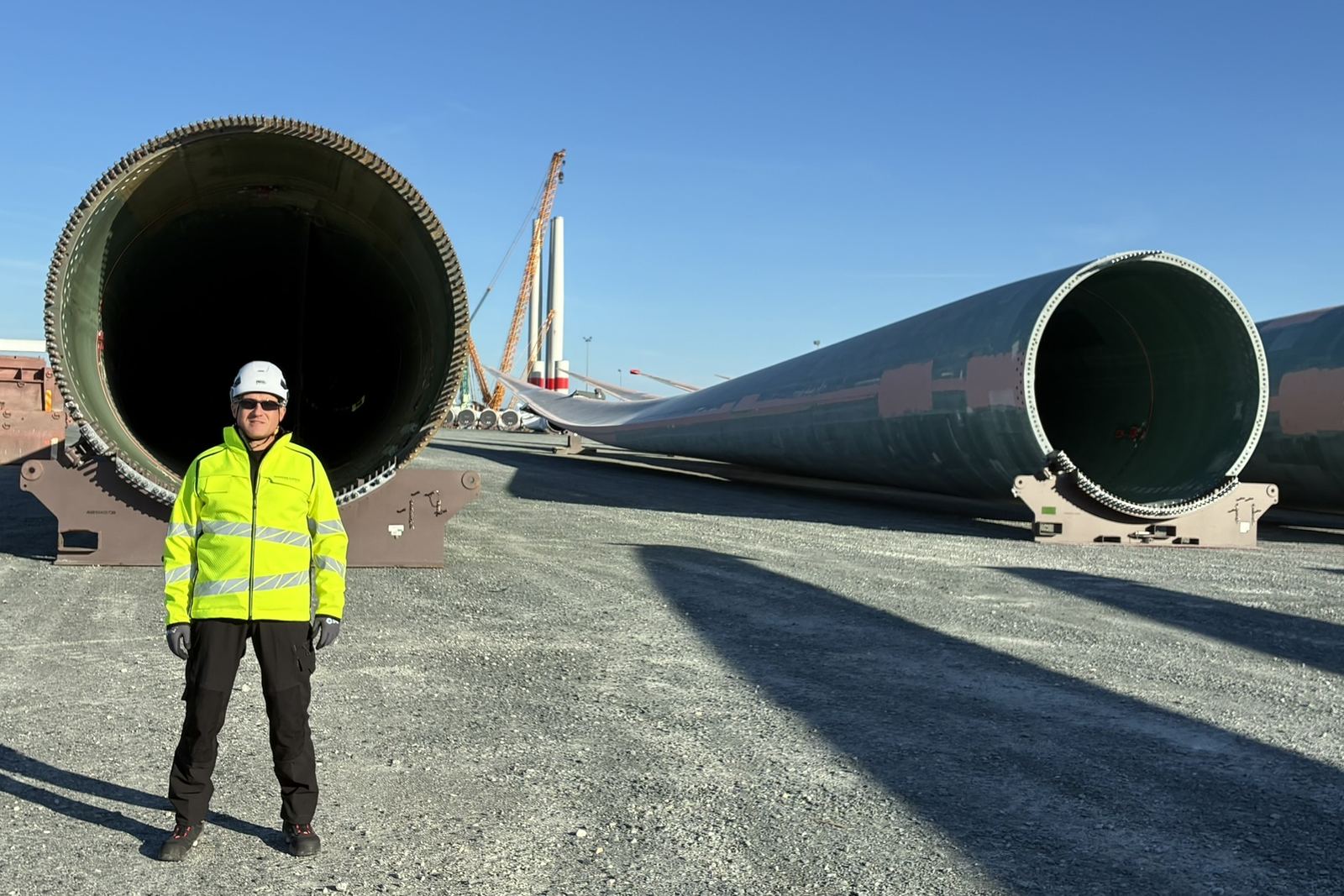 Consultant in front of monopile foundations in a marshalling yard