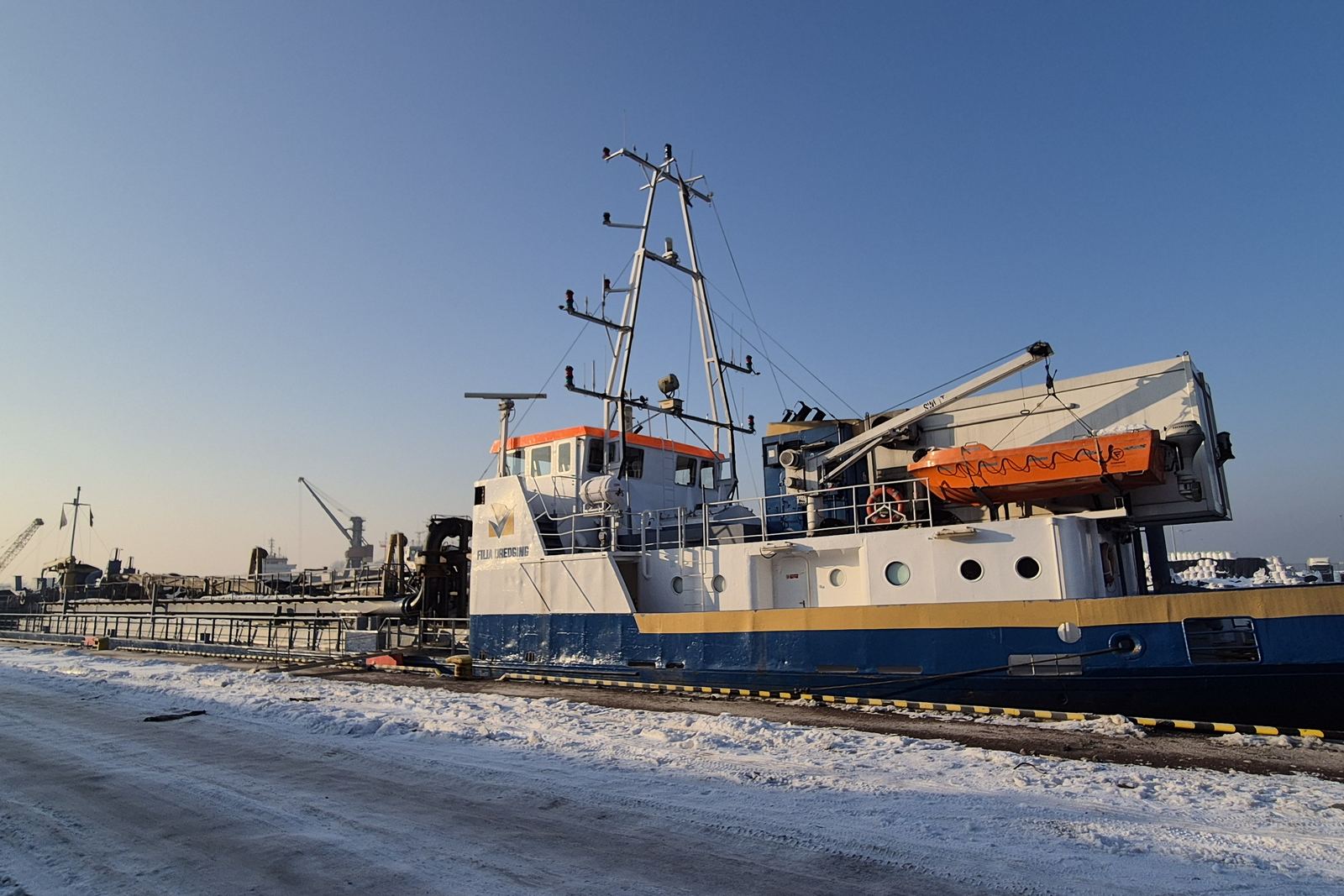 Offshore support vessel at a snowy quay